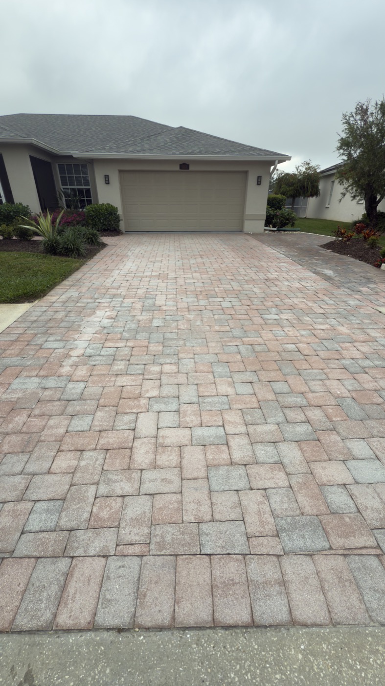 Faded paver driveway in Stoneybrook with visible white efflorescence staining before restoration