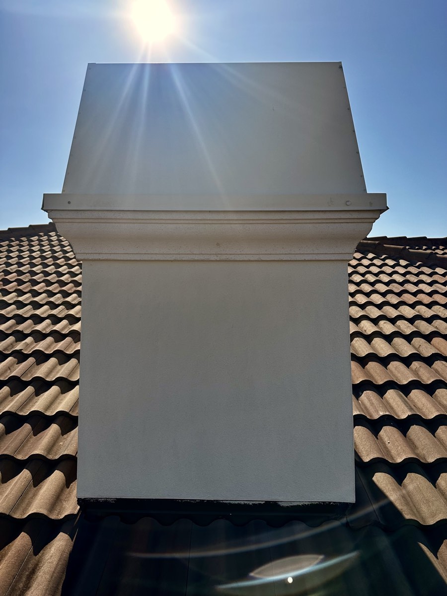 Same chimney cap clean and white after a soft wash cleaning
