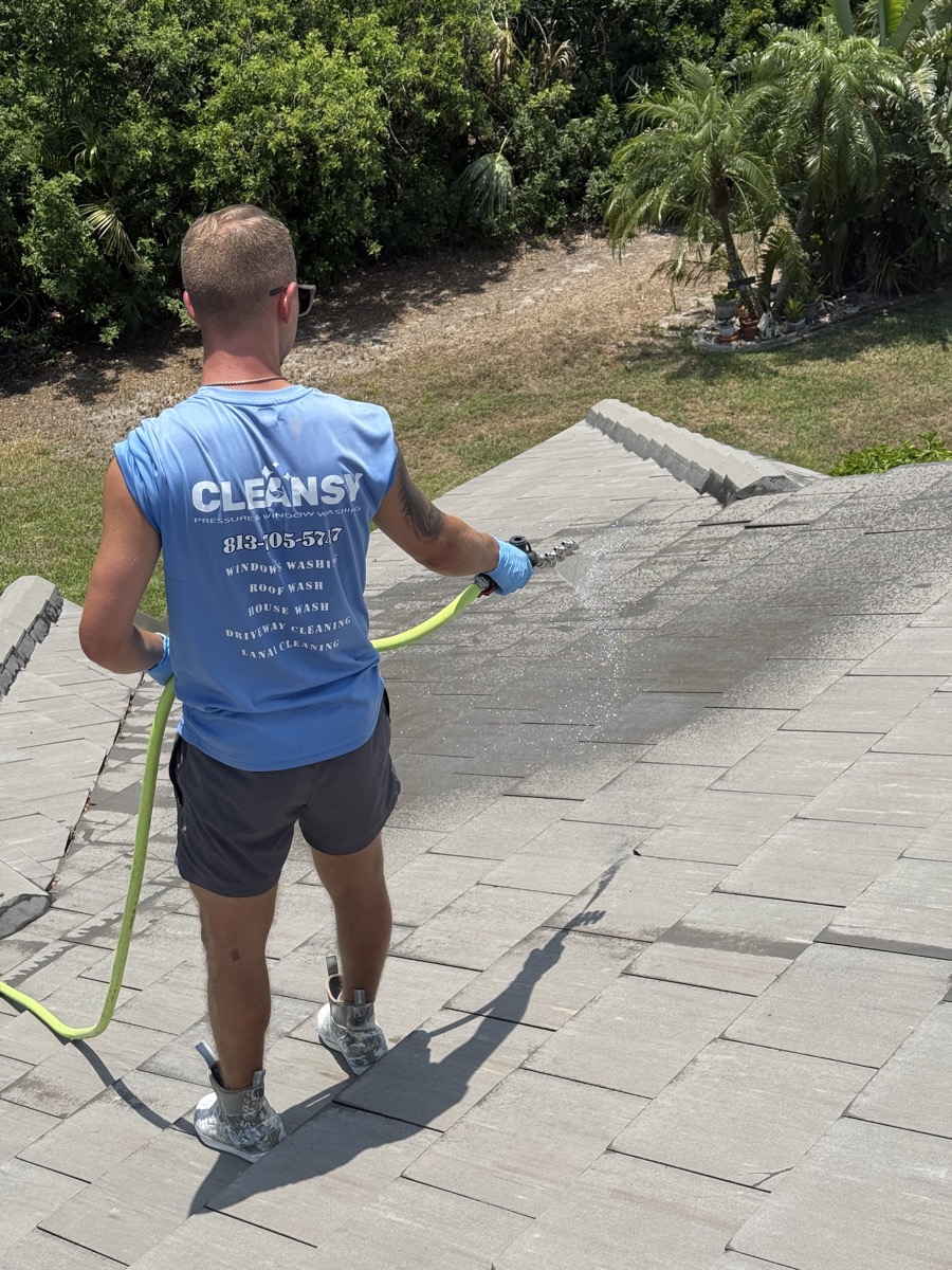 Cleansy technician soft washing a tile roof with a low-pressure sprayer