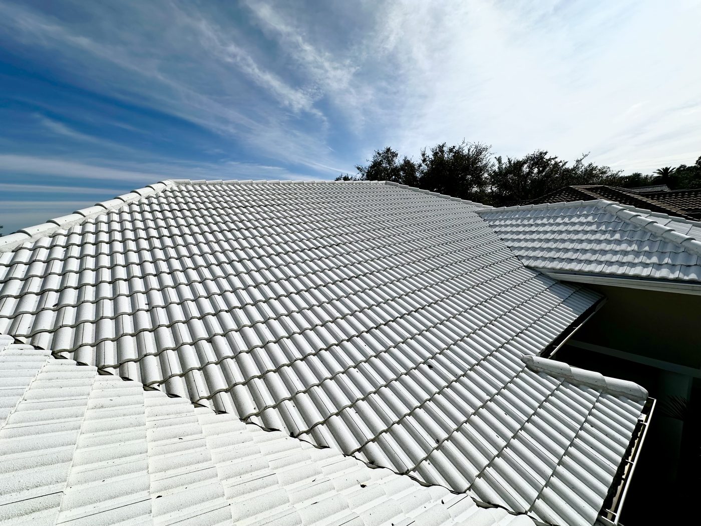 Same white tile roof after soft washing, restored to bright white