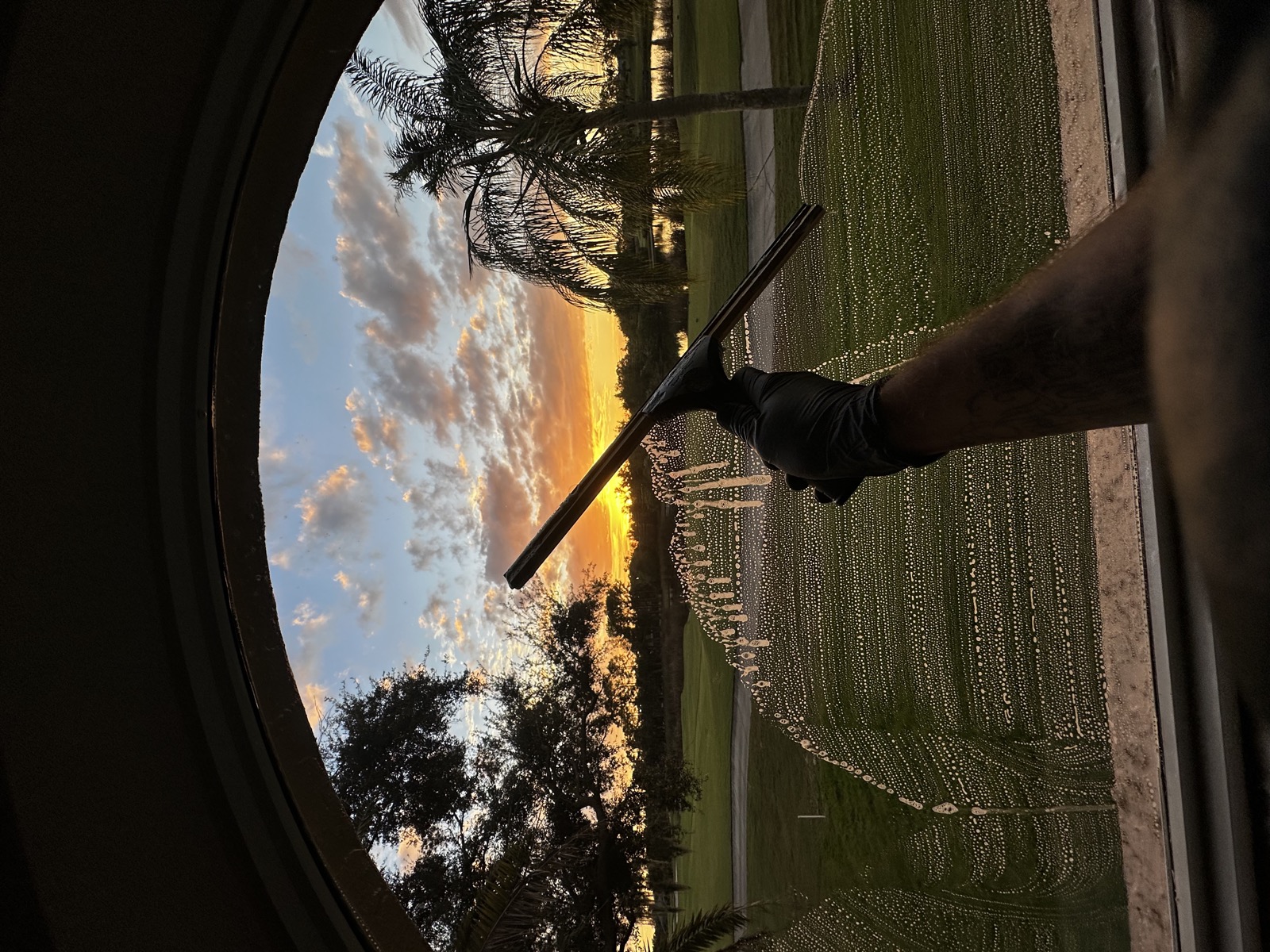 Squeegeeing a window at sunset, overlooking a Florida golf course