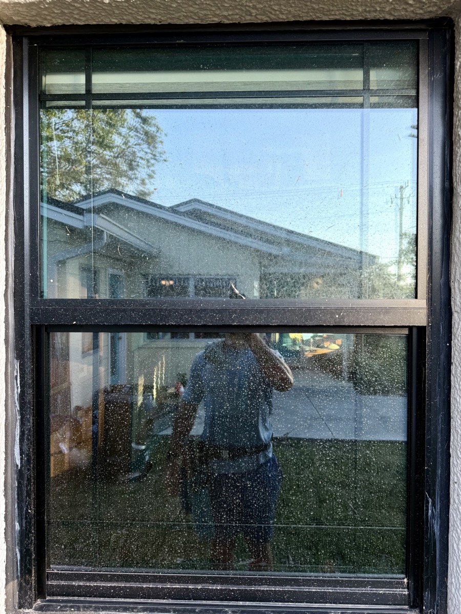 Close-up of hard water spotting and mineral residue on window glass