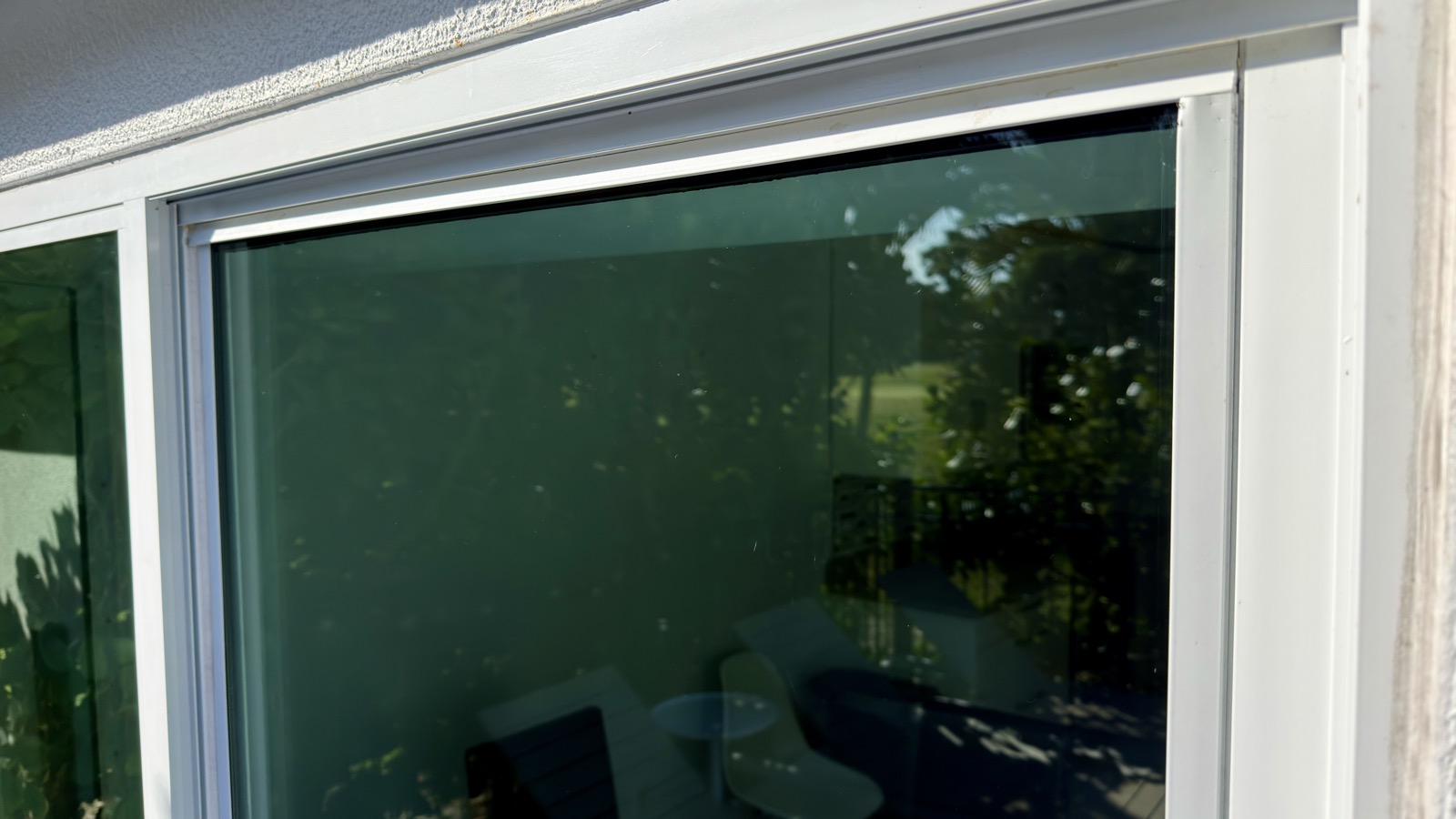 Window pane with lighter hard water spotting compared to a neighboring window