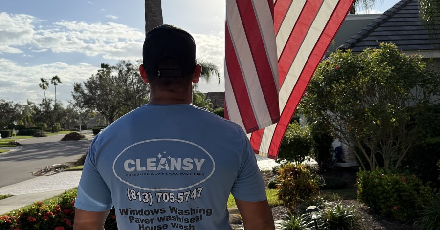 Cleansy technician standing in front of an American flag after a job in a Sarasota neighborhood