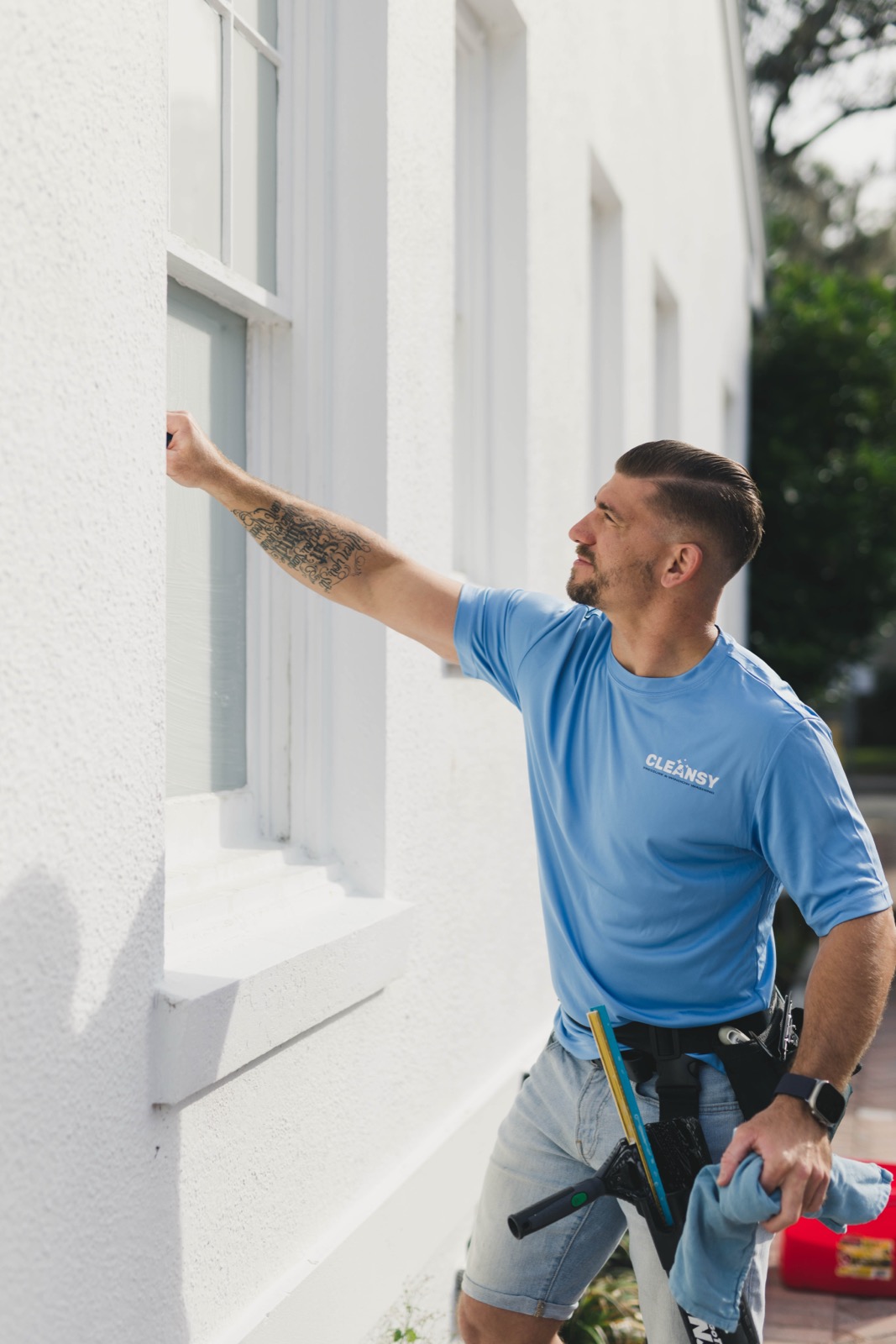 Greg from Cleansy hand-washing a window on a Sarasota home